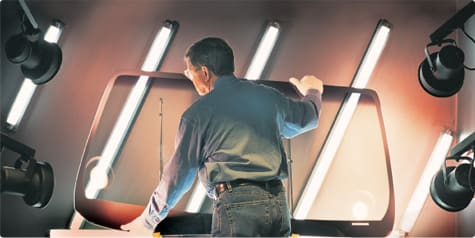 Markowe szyby samochodowe Pilkington kontrolowane są bardzo szczegółowo zdjecie pracownika pilkington trzymającego szybę